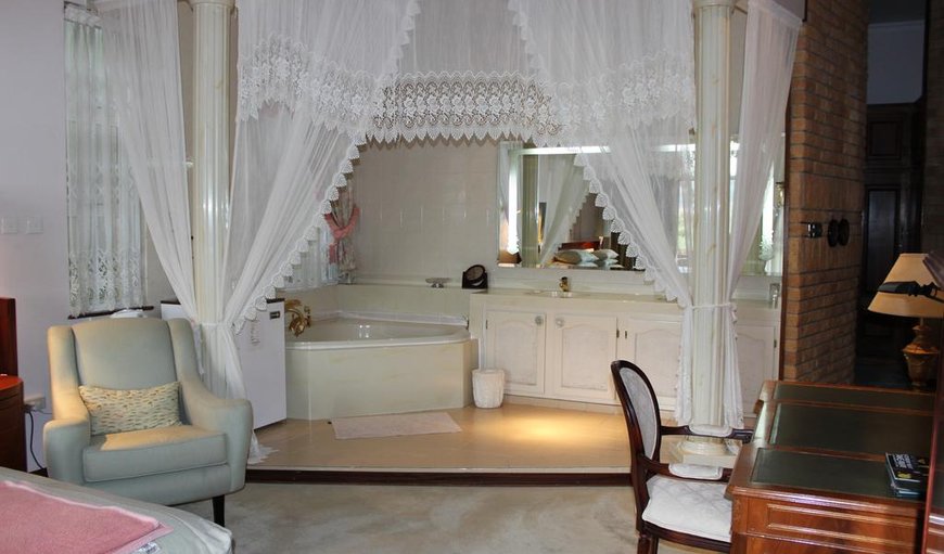 Honeymoon Suite x 1: Open planed bedroom with a double bed and corner bath