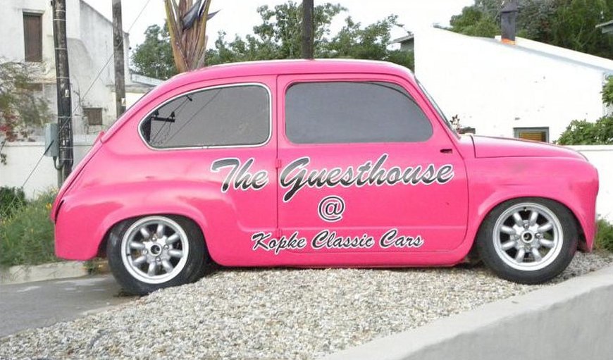 A pink sign-written Fiat 600, nicknamed "Pinky" displayed on the corner of the property