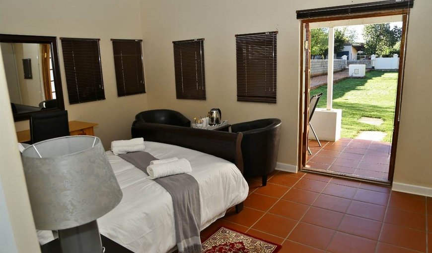 Self-catering room: Bedroom with en-suite bathroom, desk, seating area and TV